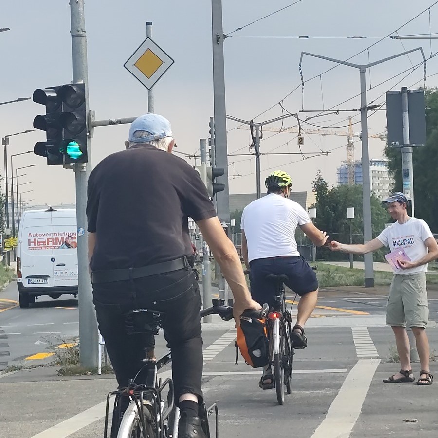 ADFC Aktiver überreicht Info Flyer an vorbeifahrenden Radfahrer